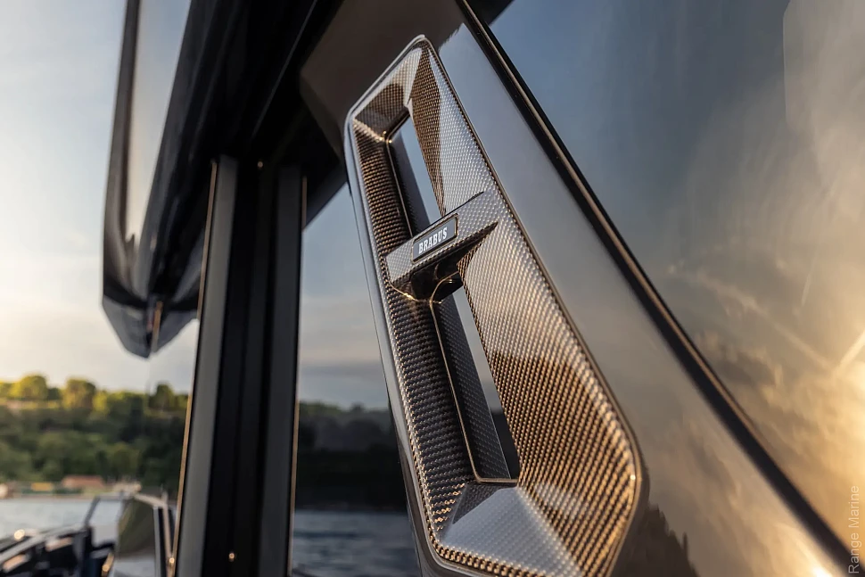 Карбоновая отделка с эмблемой BRABUS в тёплом боковом свете.